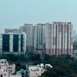 A scenic view of modern residential buildings in Hyderabad, India with lush greenery.